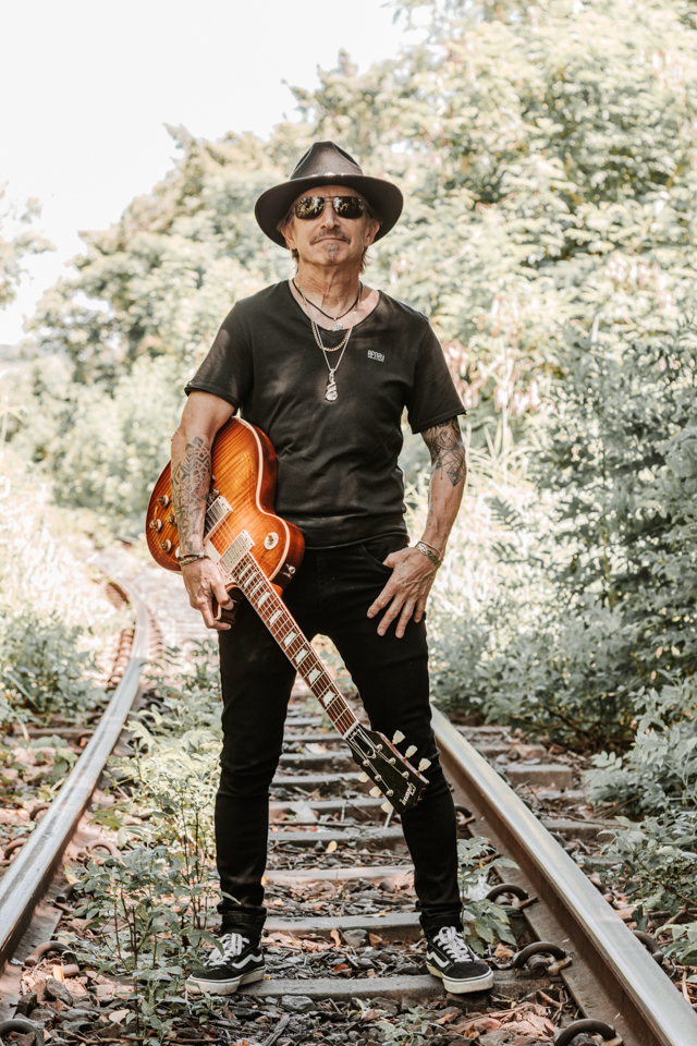 Electric guitar detail shot on railway tracks