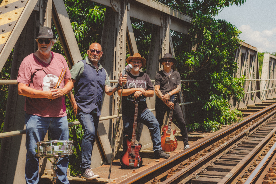 Full rock band posing on railway tracks outdoors
