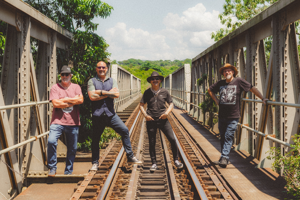 Rock band standing in strong sunlight outdoors