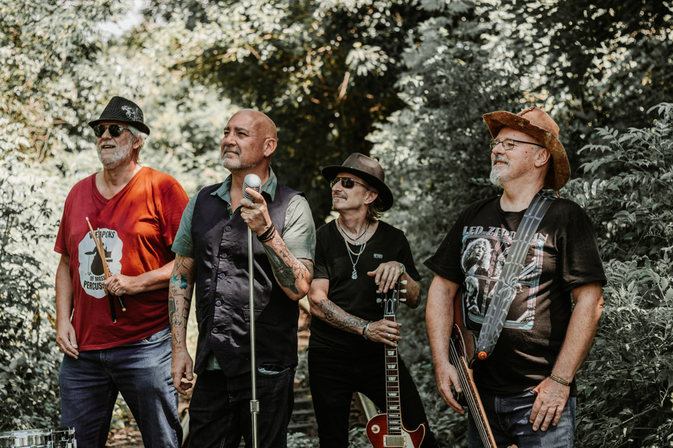 Full rock band posing on railway tracks outdoors