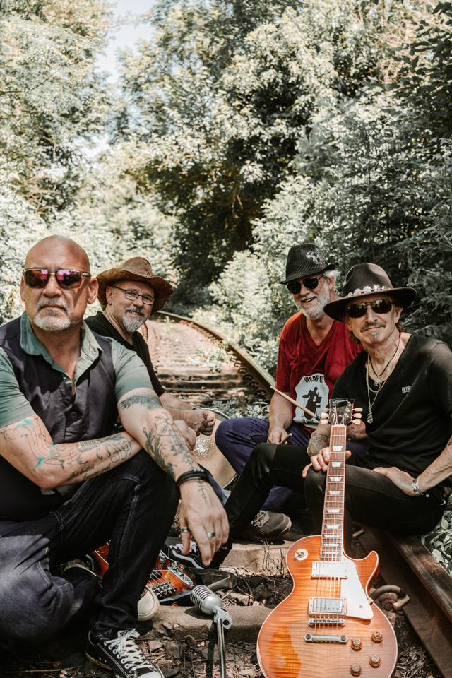 Rock band sitting on railway tracks outdoors